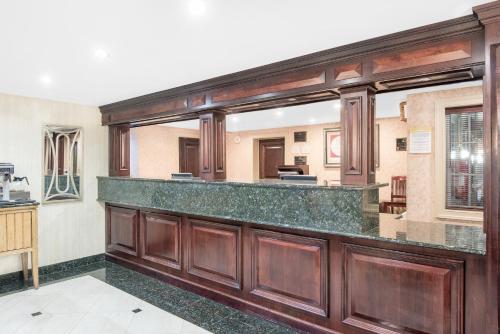a kitchen with wooden cabinets and a counter top at Days Inn by Wyndham Springfield/Phil.Intl Airport in Springfield