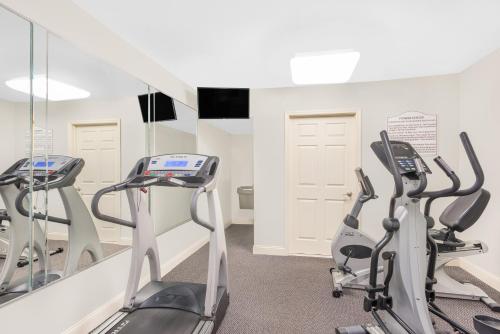a gym with treadmills and ellipticals in front of a mirror at Days Inn by Wyndham Springfield/Phil.Intl Airport in Springfield