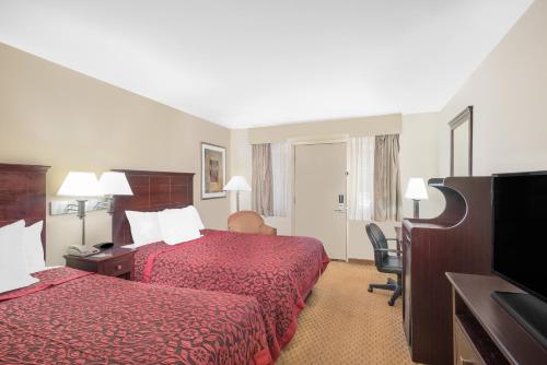 a hotel room with two beds and a flat screen tv at Days Inn by Wyndham Springfield/Phil.Intl Airport in Springfield