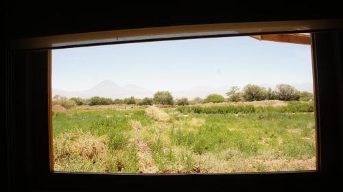a view of a field from a window at Vernacular Lodge in San Pedro de Atacama