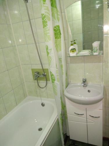 a bathroom with a sink and a tub and a sink and a sink at Apartment in the center of old town in Kamianets-Podilskyi