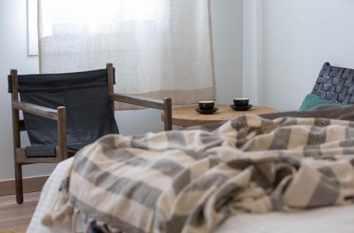 a bedroom with a bed and a table and two chairs at Amymone Suites in Nafplio