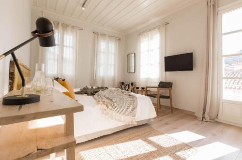 a bedroom with a bed and a desk and window at Amymone Suites in Nafplio