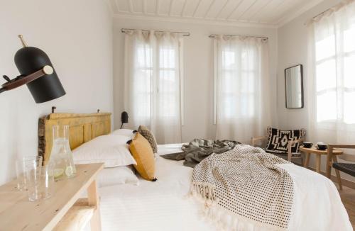a bedroom with a bed and a desk and windows at Amymone Suites in Nafplio