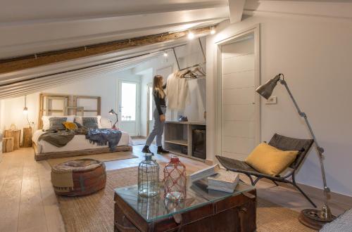 a woman is standing in a room with a bedroom at Amymone Suites in Nafplio