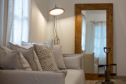 a living room with a couch and a mirror at Amymone Suites in Nafplio