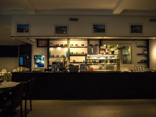 a bar in a restaurant with a counter and a refrigerator at Bremanger Fjord Hotell in Svelgen