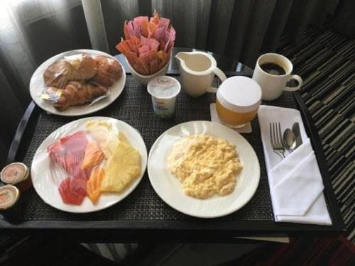 a black table with plates of breakfast foods and coffee at Radisson Blu Okoume Palace Hotel, Libreville in Libreville