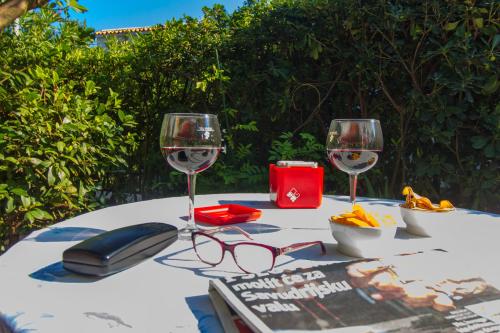 una mesa con tres copas de vino y un libro en Apartment Jadrija en Šibenik