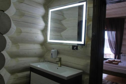 a bathroom with a sink and a mirror and a window at Berloga Pylypets in Pilipets