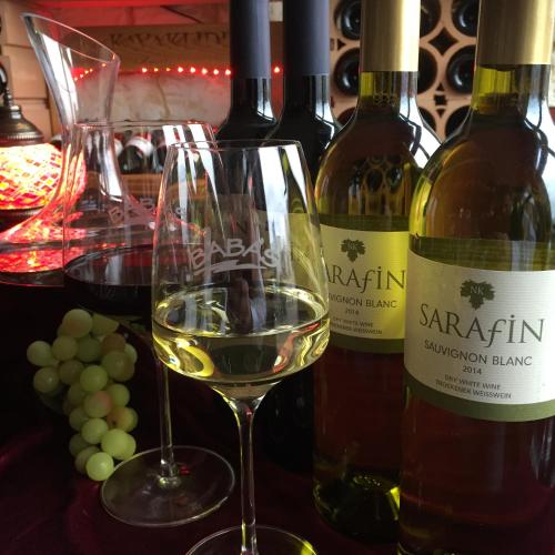 a glass of white wine next to some bottles of wine at Aparthotel Berlin in Bad Nenndorf