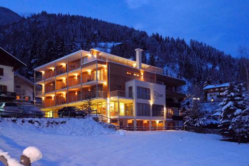 a large building in the snow at night at Vitalhotel Rainer in Ultimo