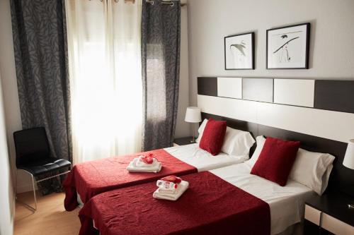 Habitación de hotel con 2 camas en rojo y blanco en Alcam Valencia II, en Barcelona