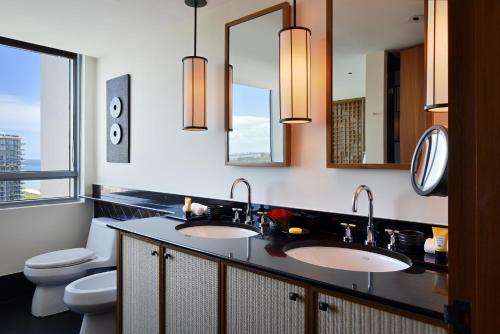 La salle de bains est pourvue de 2 lavabos, de toilettes et de miroirs. dans l'établissement The Setai, Miami Beach, à Miami Beach