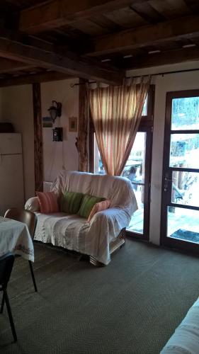 a bed sitting in a room with a window at Cabana Belis Dealu Negru in Beliş