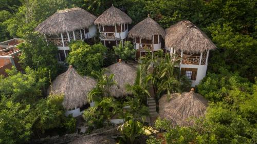 an aerial view of a resort building with thatched roofs at Cabañas Biuzaa in Zipolite