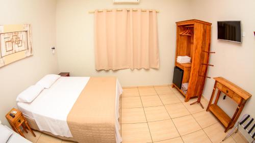 a bedroom with a bed and a television in it at Hotel Winner in Barretos