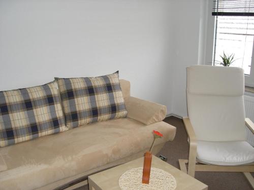 a living room with a couch and a chair at Zimmervermietung Schönfließer Stuben auch für Monteure in Eisenhüttenstadt