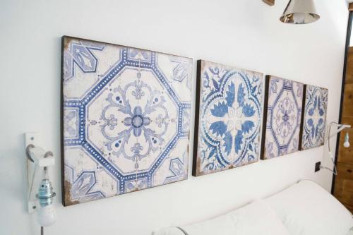 four blue and white tiles on a wall with a couch at Rocca d'Anfo B&B-Apartments Lake View in Rocca dʼAnfo