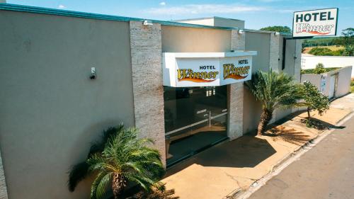 a hotel with a sign on the side of a building at Hotel Winner in Barretos