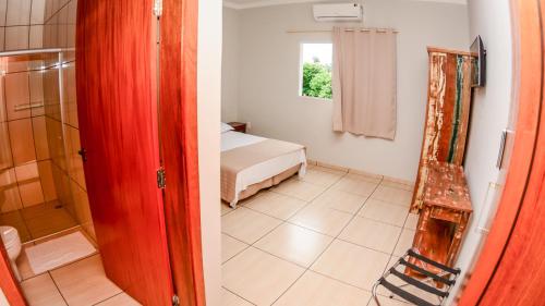 a bedroom with a bed and a bathroom with a shower at Hotel Winner in Barretos
