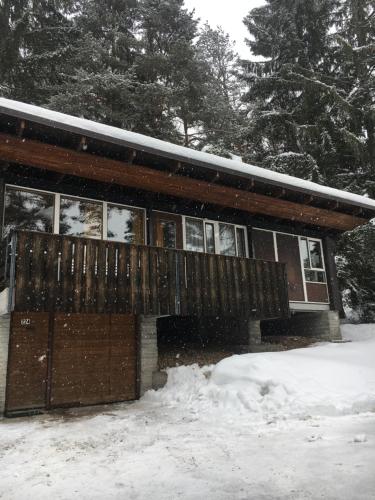 ein schneebedecktes Haus mit einer Terrasse in der Unterkunft Villa Borca di Cadore in Borca di Cadore