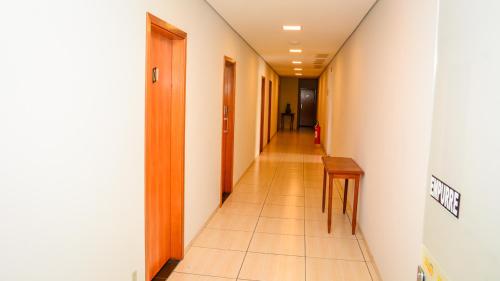 a hallway with a long corridor with a table and chairs at Hotel Winner in Barretos
