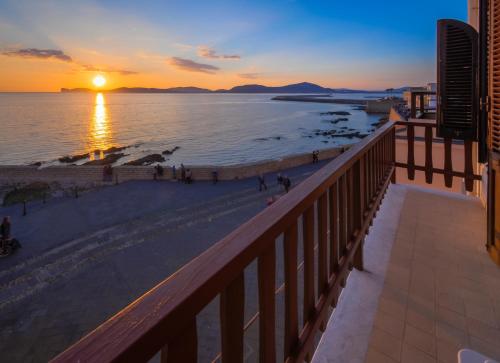 a view of the beach at sunset from the balcony of a condo at Alguerhome Casa Blu sea view in Alghero