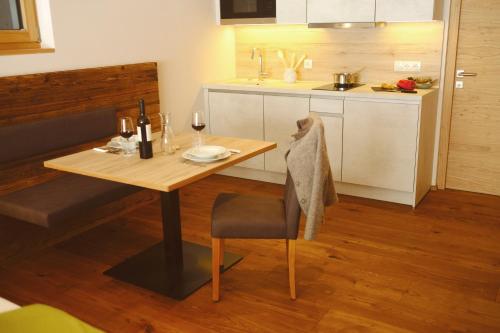 a small kitchen with a wooden table and a dining room at Unterlutaschg-Chalet Appartement am Hof in Slingia