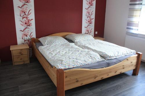 ein Schlafzimmer mit einem Holzbett in einem Zimmer in der Unterkunft Ferienhaus Schaumann in Ditzum