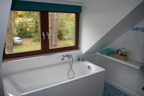een badkamer met een bad en een raam bij Waterlelie 34 Rekem in Rekem