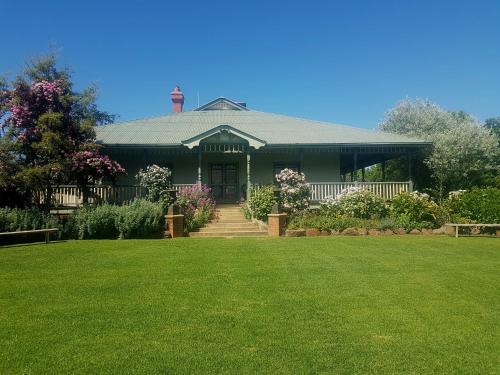 a green house with a lawn in front of it at Orange Grove Gardens in Weeamera