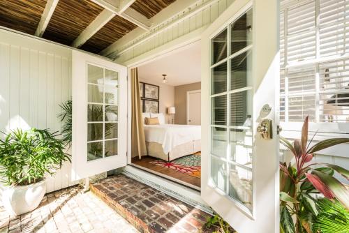 a home with a porch with a bed and a bedroom at Old Town Manor in Key West