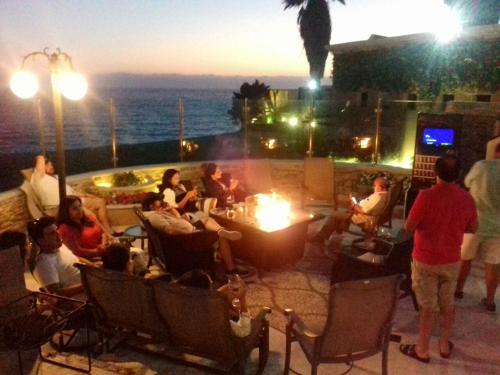 a group of people sitting on a patio at night at La Mansión Residency Suites Ensenada in Ensenada