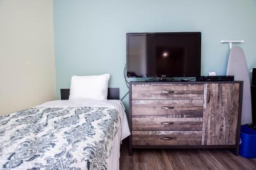 a bedroom with a bed and a tv on a dresser at United College in Waterloo