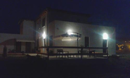 a building with two chairs and lights at night at Alma Bed & Breakfast in Sennariolo