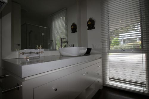 a white bathroom with a sink and a mirror at Lorne Holiday House in Lorne