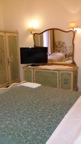 ein Schlafzimmer mit einem Bett mit einer Kommode und einem Spiegel in der Unterkunft Casa Maya Souvenir in Florenz