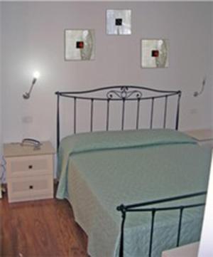 a bedroom with a bed with a green bedspread and a night stand at Luconi Affittacamere in Iesi