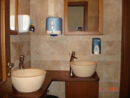 a bathroom with two sinks and two soap dispensers at Olympios Zeus Hotel in Kato Zachlorou