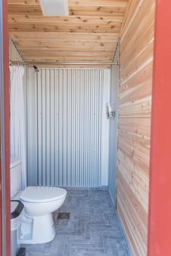 a bathroom with a toilet and a wooden wall at Under Canvas Great Smoky Mountains in Pigeon Forge