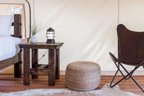 a bedroom with a bed and a table and a chair at Under Canvas Great Smoky Mountains in Pigeon Forge