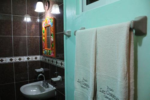 y baño con lavabo, espejo y toallas. en Posada Los Chaneques Catemaco, en Catemaco
