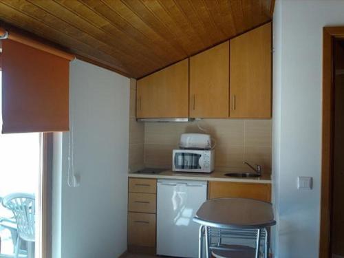 a small kitchen with a stove and a microwave at Casa da muralha in Figueira da Foz