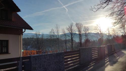 a fence in front of a house with a view of the mountains at Uroczysko starych sztolni in Szklarska Poręba