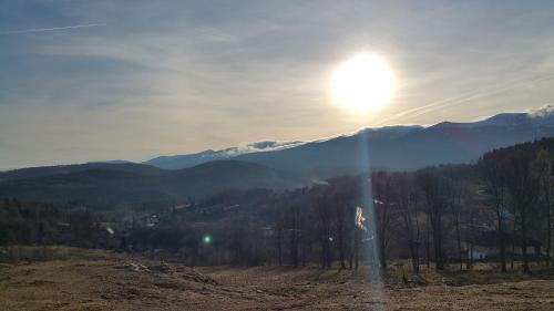 a view of a mountain with the sun in the sky at Uroczysko starych sztolni in Szklarska Poręba