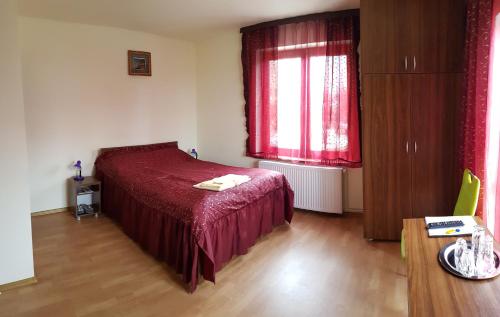 a bedroom with a red bed and a window at Floare de Colț in Sibiu