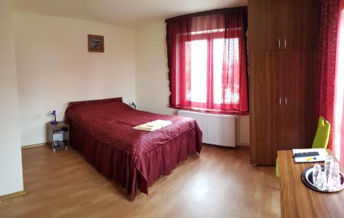 シビウにあるFloare de Colțのベッドルーム1室(赤いベッド1台、窓付)