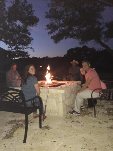 a group of people sitting around a table with a fire at Glory Hills Ranch in Pipe Creek