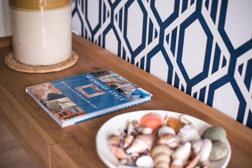 a table with a plate of mushrooms and a magazine at Seahurst Apartment in Eskdale